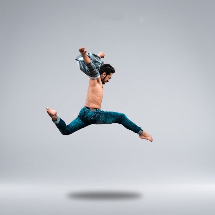 why-choose-us A male dancer shows his agility with a powerful leap captured in a studio setting.