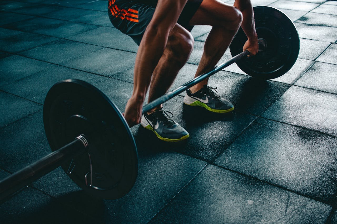 gallery-3 Man performing a deadlift exercise in a gym, demonstrating strength and fitness.